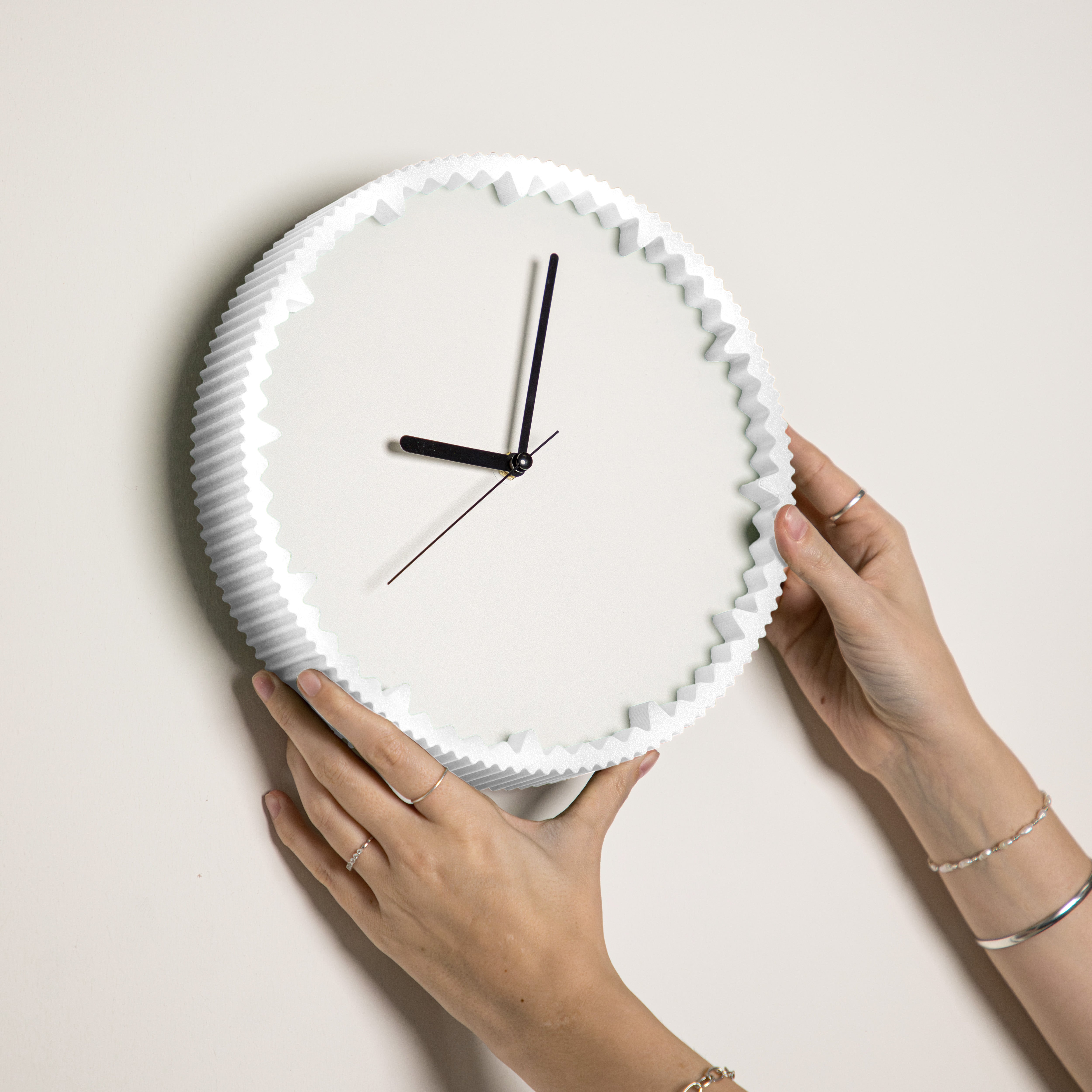 Hände hängen moderne Wanduhr weiss mit gezacktem Rand aus dem 3D Druck an die Wand #farbe_weiß