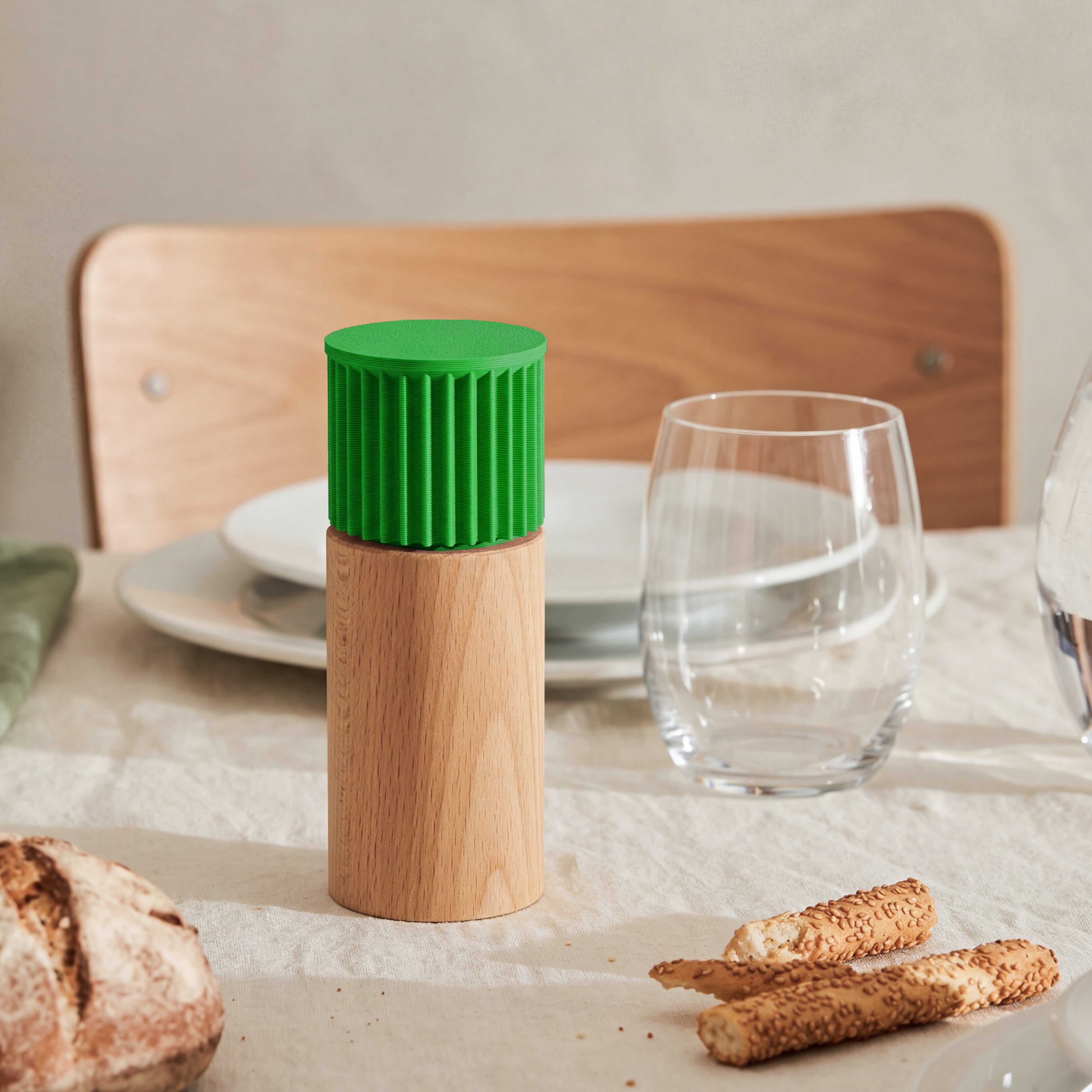 Gewürzmühle Prise in Grün aus Buchenholz auf gedecktem Tisch mit Brot und Wasserglas #farbe_grün