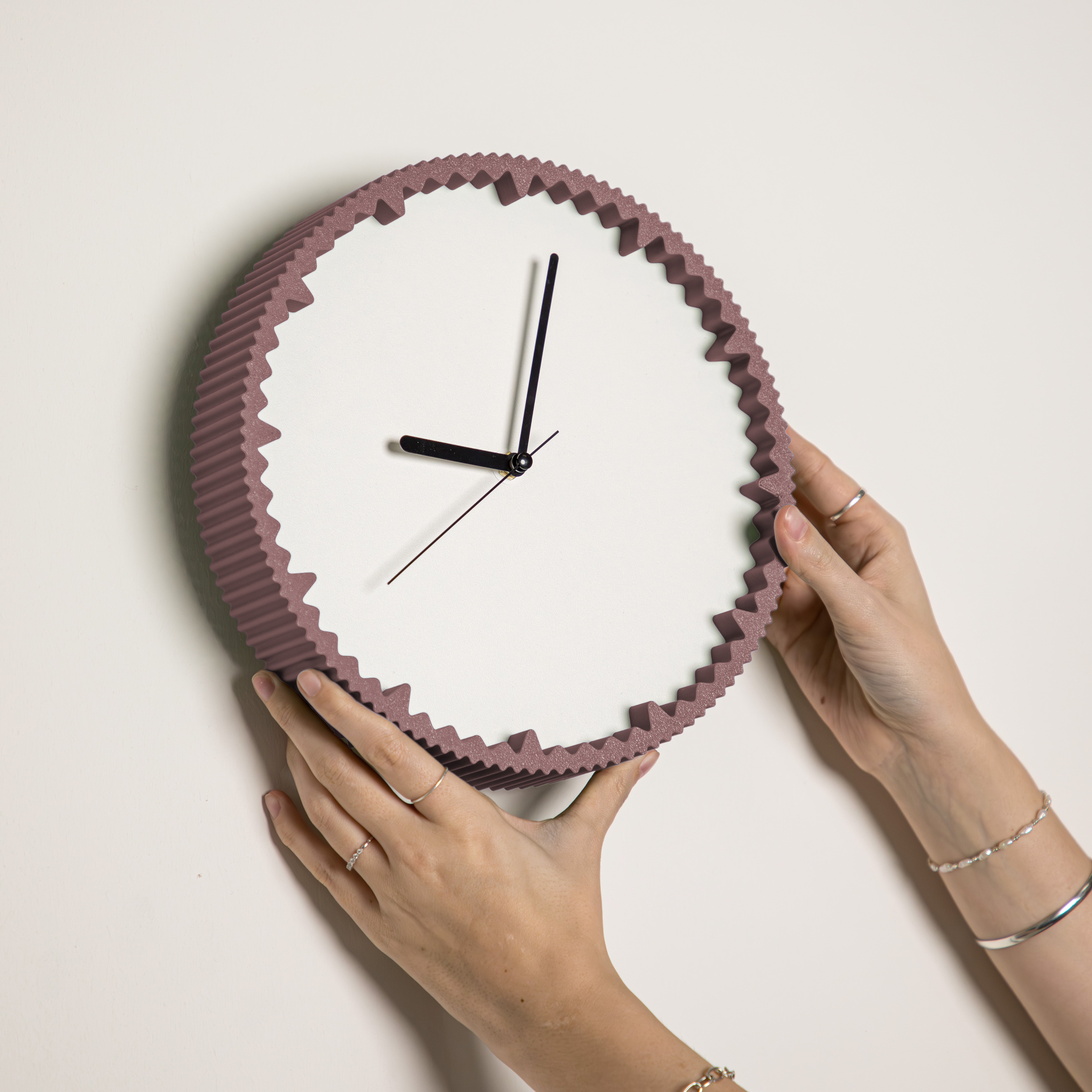Hände hängen moderne Wanduhr lila mit gezacktem Rand aus dem 3D Druck an die Wand #farbe_aschlila