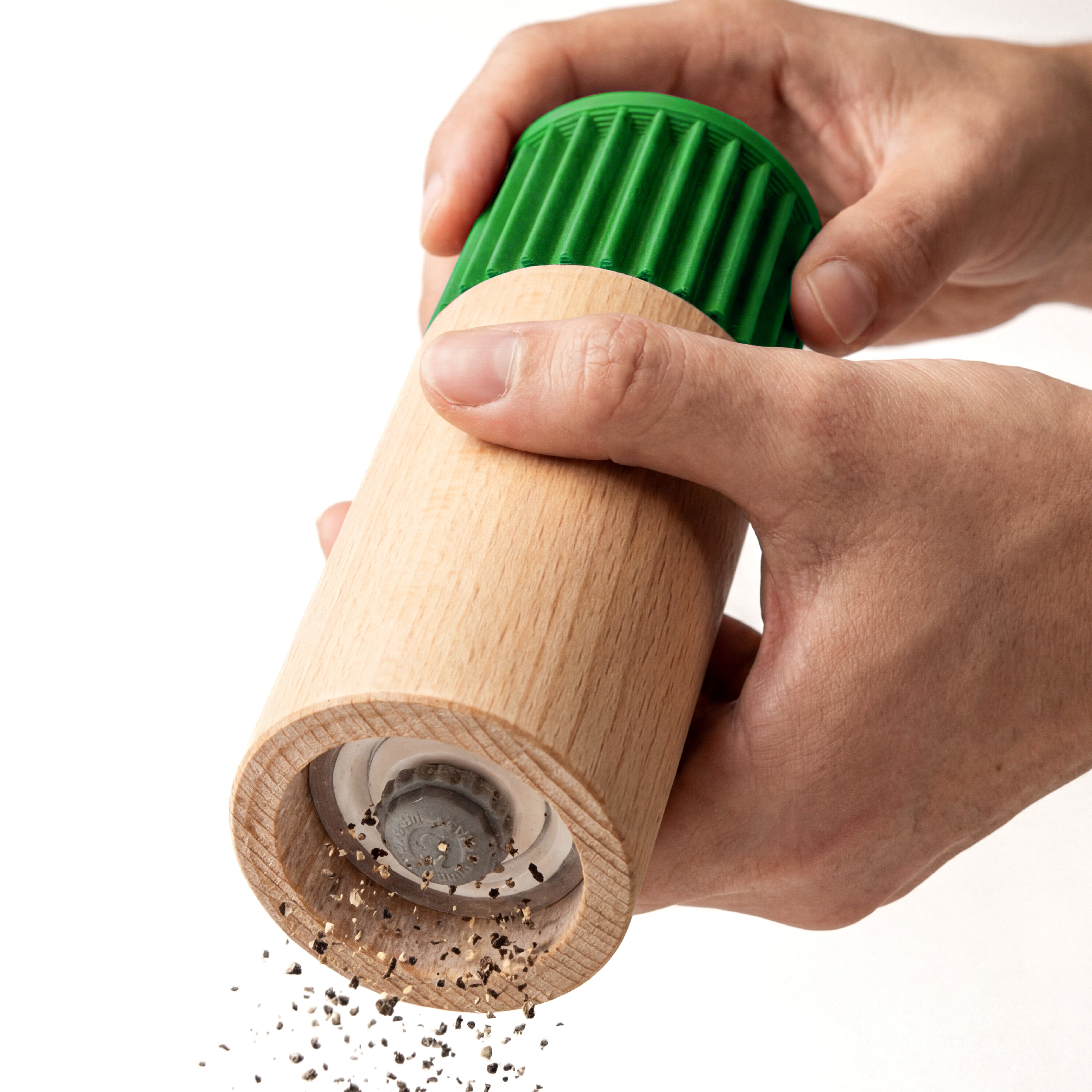 Hände mahlen Pfeffer mit der Gewürzmühle Prise in Grün aus Buchenholz vor weißem Grund #farbe_grün