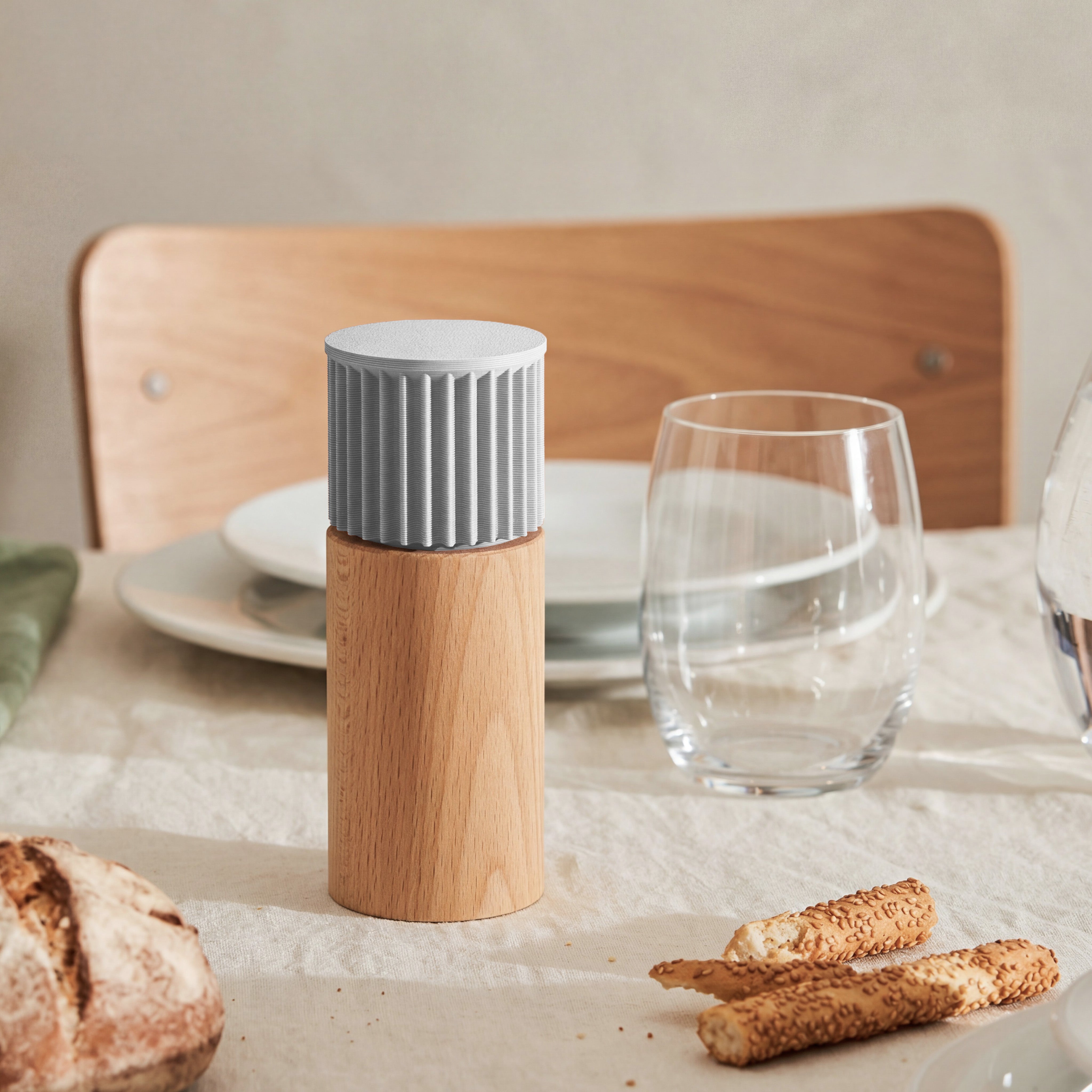 Gewürzmühle Prise in Grau aus Buchenholz auf gedecktem Tisch mit Brot und Wasserglas #farbe_hellgrau