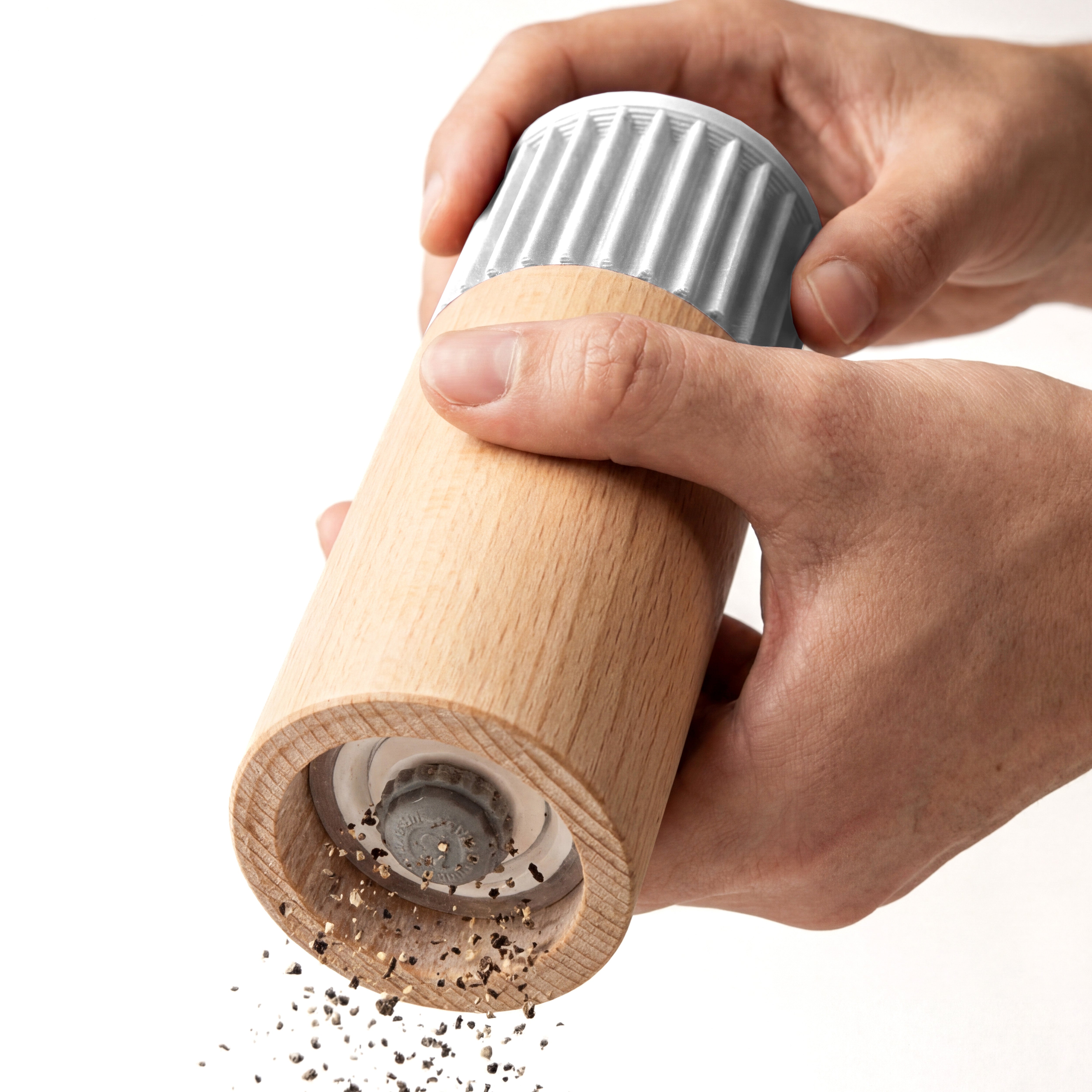 Hände mahlen Pfeffer mit der Gewürzmühle Prise in weiß aus Buchenholz vor weißem Grund #farbe_weiß