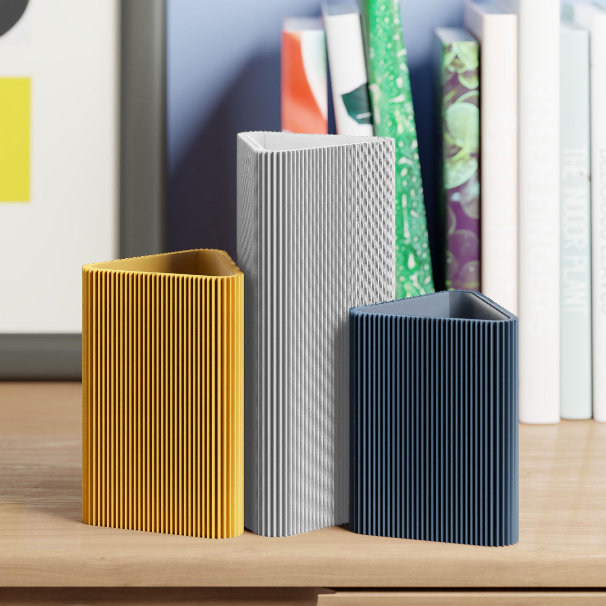 Geometrische Vase DREIECK in hellgrau mit zwei weiteren Vasen vor Büchern im Regal #farbe_hellgrau