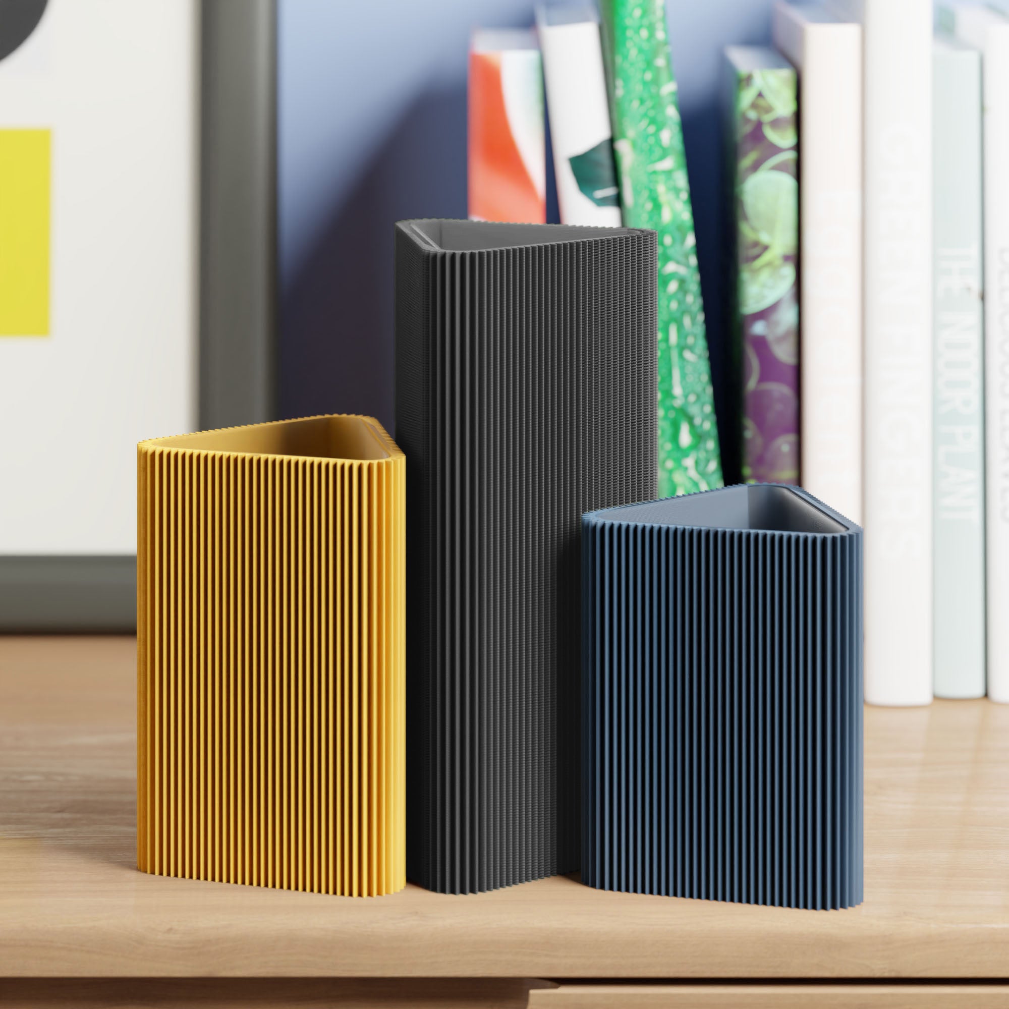 Geometrische Vase DREIECK in schwarz mit zwei weiteren Vasen vor Büchern im Regal #farbe_schwarz