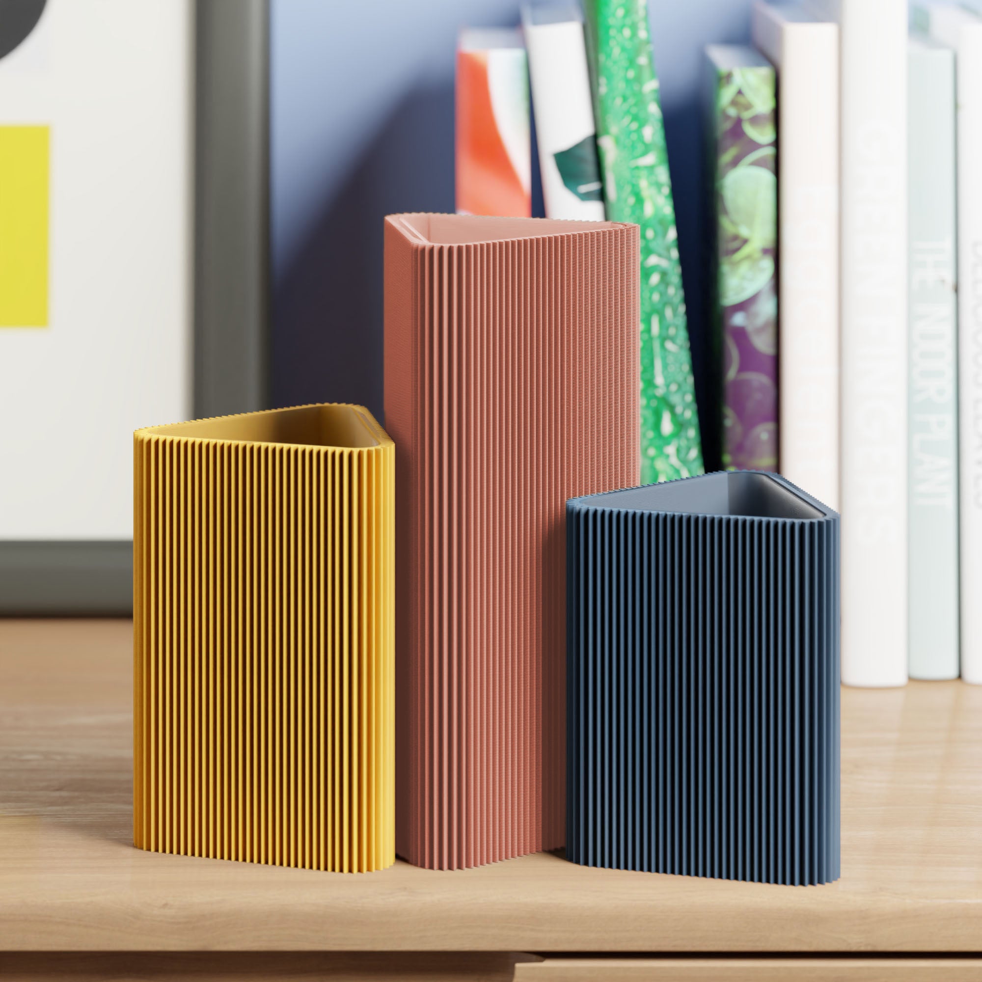 Geometrische Vase DREIECK in terracotta mit zwei weiteren Vasen vor Büchern im Regal #farbe_terracotta