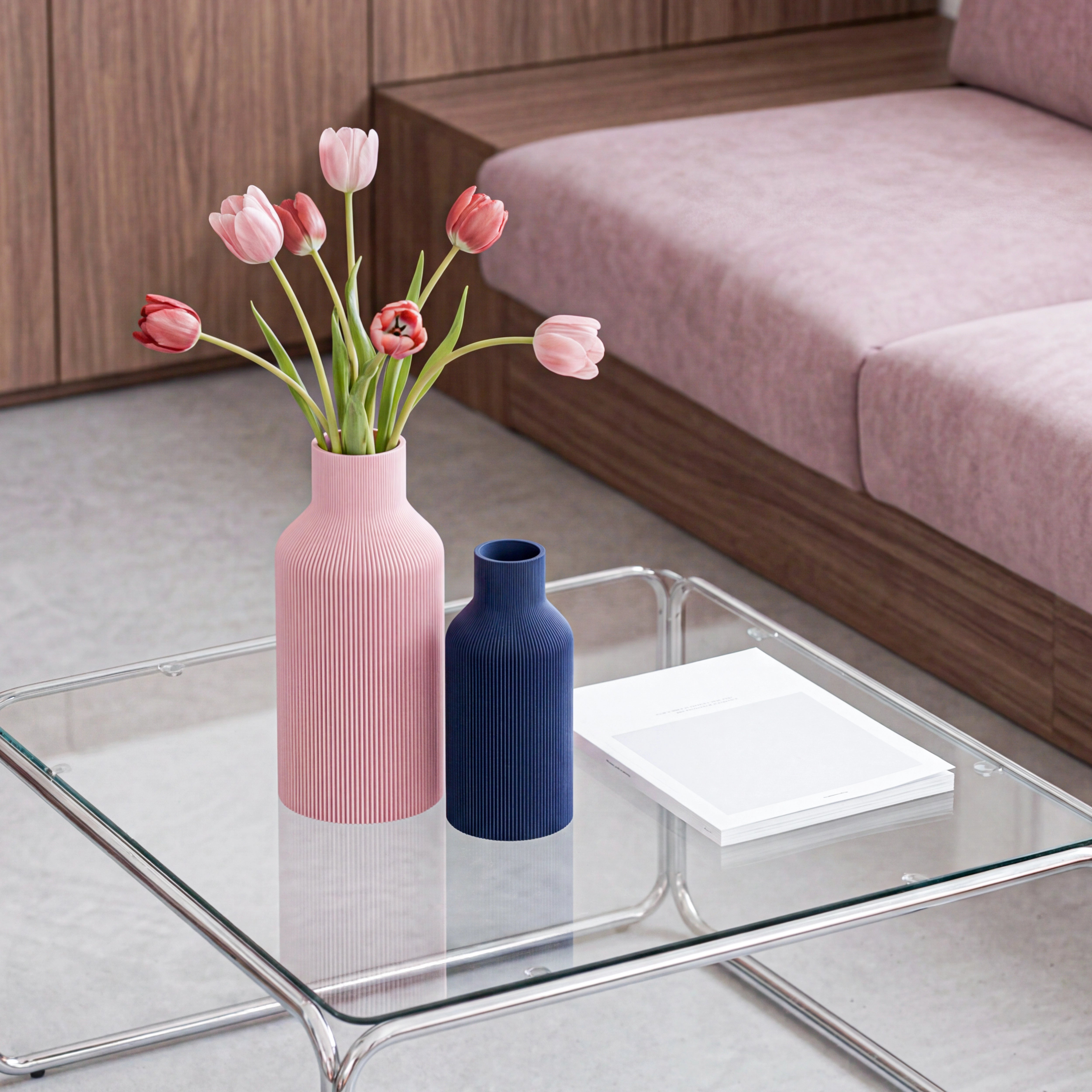 Zwei Vasen in Flaschenform aus dem 3D Druck in Rosa und Navyblau mit Tulpen auf Glastisch